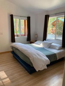 a bedroom with a large bed with a large window at Talkeetna Wilderness Lodge & Cabin Rentals in Sunshine