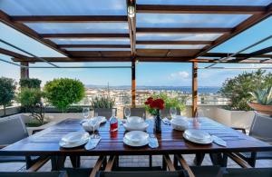 een houten tafel met borden en servetten op een patio bij Living exceptionally in Thessaloniki