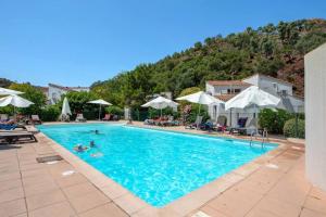 une piscine dans un hôtel avec des gens qui y nagent dans l'établissement La Casa Mandelieu, à Mandelieu-la-Napoule