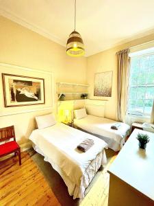 a bedroom with two beds and a table and a chair at Central Edinburgh - Large groups in Edinburgh