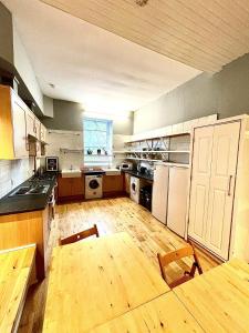 a large kitchen with wooden floors and white appliances at Central Edinburgh - Large groups in Edinburgh