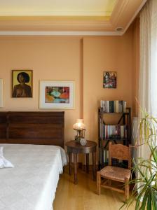 een slaapkamer met een bed, een tafel en een stoel bij Living exceptionally in Thessaloniki