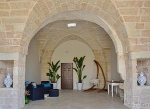 une arche dans un bâtiment avec une porte et des plantes dans l'établissement LeVolte luxury suite&spa, à Sternatia