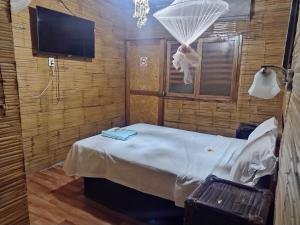 een kamer met een bed en een televisie in een kamer bij Hospedaje - Restobar Atlantis Máncora in Máncora