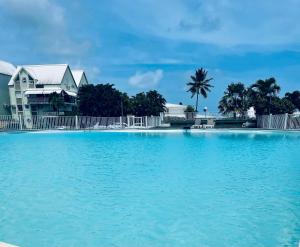a large pool of water in front of a house at Studio le Colibri, Entre terre et mer, vue incroyable, citerne in Le Gosier