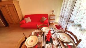 - un salon avec une table et un canapé rouge dans l'établissement Au Doubs Refuge, à Métabief