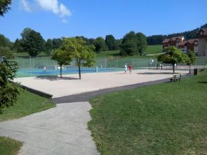 un parc avec des personnes et un terrain de volley-ball dans l'établissement Au Doubs Refuge, à Métabief