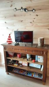 a wooden entertainment center with a television on top at Au Doubs Refuge in Métabief