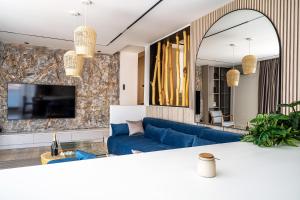a living room with a blue couch and a mirror at Blanche Cliff Apartments in Sveti Stefan