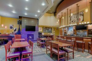 Un restaurante con mesas y sillas de madera y chimenea. en Best Western Plus Loveland Inn, en Loveland