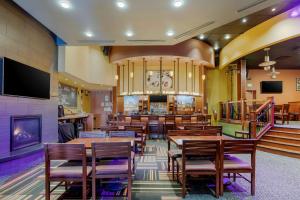 Un restaurante con mesas y sillas de madera y un bar. en Best Western Plus Loveland Inn, en Loveland