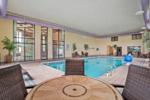 an indoor pool with chairs and a table and a swimming pool at Best Western Vicksburg in Vicksburg