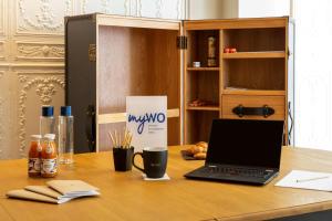 a laptop computer sitting on top of a wooden desk at Les Demeures de Varennes, BW Signature Collection in Varennes-Jarcy