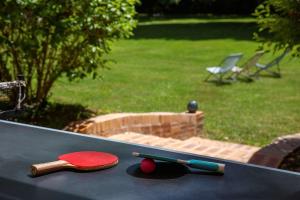 two ping pong rackets and balls on a table at Les Demeures de Varennes, BW Signature Collection in Varennes-Jarcy