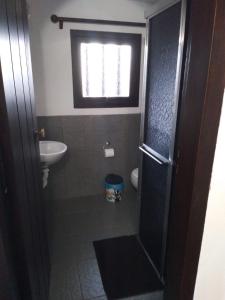 a bathroom with a sink and a toilet and a window at Pousada Vênus in Monte Verde