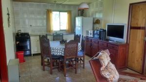 a kitchen with a table with chairs and a television at Cabañas del Sol in Potrerillos