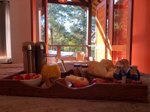 a tray of food with fruit and juice and drinks at Afha 48 in Monte Verde +17 photos