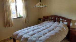 Schlafzimmer mit einem weißen Bett vor einem Fenster in der Unterkunft Cabañas del Sol in Potrerillos + 41 Fotos