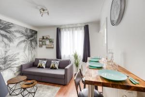 a living room with a table and a couch at Le Somptueux aux portes de Paris PARKING Gratuit in Bagneux