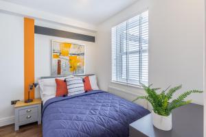 a bedroom with a purple bed and a window at Bright cheery 4 bd apartment by Brighton Station in Brighton & Hove