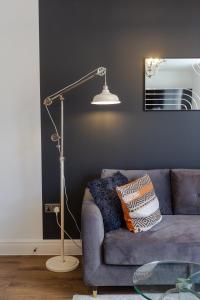 a lamp in a living room with a blue couch at Bright cheery 4 bd apartment by Brighton Station in Brighton & Hove