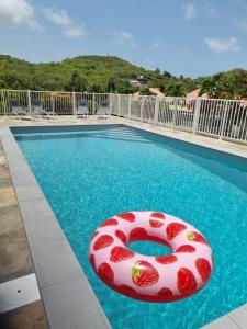 a swimming pool with a red life ring in the water at Villa MALOEM in Sainte-Anne