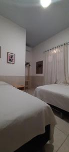 biała sypialnia z dwoma łóżkami i oknem w obiekcie HOSPEDARIA CONSULADO PAULISTA w mieście Taíba +23 zdjęcia