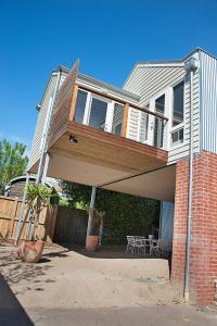 a house with a deck with a table on it at Salt Loft in Queenscliff