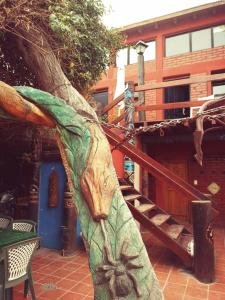 a tree trunk with a face on it next to a building at el refugio piramides in Puerto Pirámides