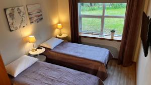 two beds in a small room with a window at Westfjords - Rooms in Bolungarvík +14 photos