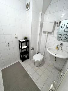 a white bathroom with a toilet and a sink at Apartment 777 in Bijelo Polje
