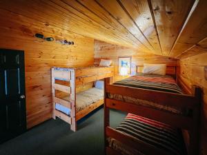 a bedroom with two bunk beds in a log cabin at Angler's Lodge in Island Park