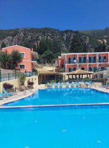 a large blue swimming pool in front of a building at Maria Studios in Paleokastritsa