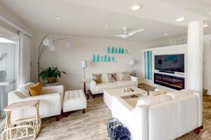 sala de estar con muebles blancos y TV en Oceanview Paradise, en Watsonville