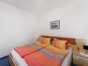 a bed with colorful blankets on it in a room at Schattbergblick in Saalbach-Hinterglemm