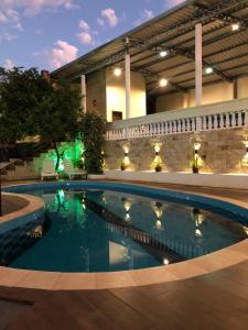 a swimming pool in front of a building at night at Hotel del Parque in Ciudad del Este