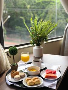 a breakfast tray with food and a glass of orange juice at Hotel del Parque in Ciudad del Este