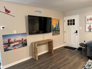 a living room with a large flat screen tv on a wall at Experience Raleigh NC 8 minutes from the heart in Raleigh