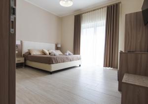 1 dormitorio con cama y ventana grande en Luxury House, en Villapiana