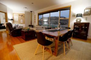 a living room with a wooden table and chairs at Stanley Beach House with Stunning Nut Views! in Stanley