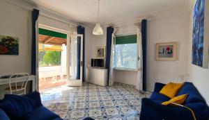 a living room with a blue couch and a television at Villa Matisse - Damecuta Park in Anacapri
