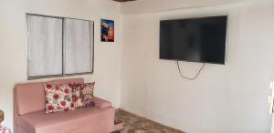 un soggiorno con sedia rosa e TV a schermo piatto di Casa campestre Villa Eliana 2 a Calarcá