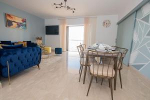 ein Wohnzimmer mit einem Tisch, Stühlen und einem Sofa in der Unterkunft Blu paradise,a ray of sunshine between sea & pool in Agadir