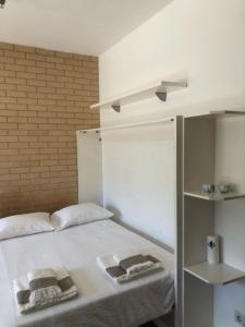 a bedroom with a white bed with towels on it at T0 no centro do Porto in Porto