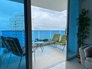 Habitación con balcón con sillas y mesa. en Santa Marta Condominio Reserva del Mar Playa Salguero frente al Mar, en Santa Marta