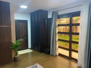 Habitación con puerta y ventana con planta en Suite La Patera & El colibri, en Ayampe