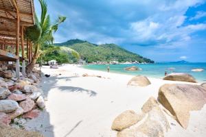 a beach with rocks and people in the water at Crystal Bay Yacht Club Beach Resort in Lamai