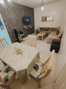 Superbe appartement au rez-de-chaussée avec clim mobile,parking et wifi gratuit في الدار البيضاء: غرفة معيشة مع طاولة وأريكة