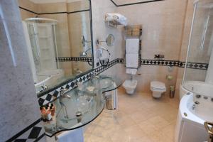 
a bathroom with a sink, toilet, and bathtub at Livingston Hotel & Spa in Syracuse
