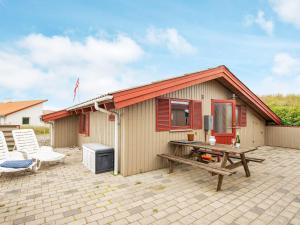 een klein huis met een picknicktafel en een bank bij Holiday home Hvide Sande CXI in Bjerregård